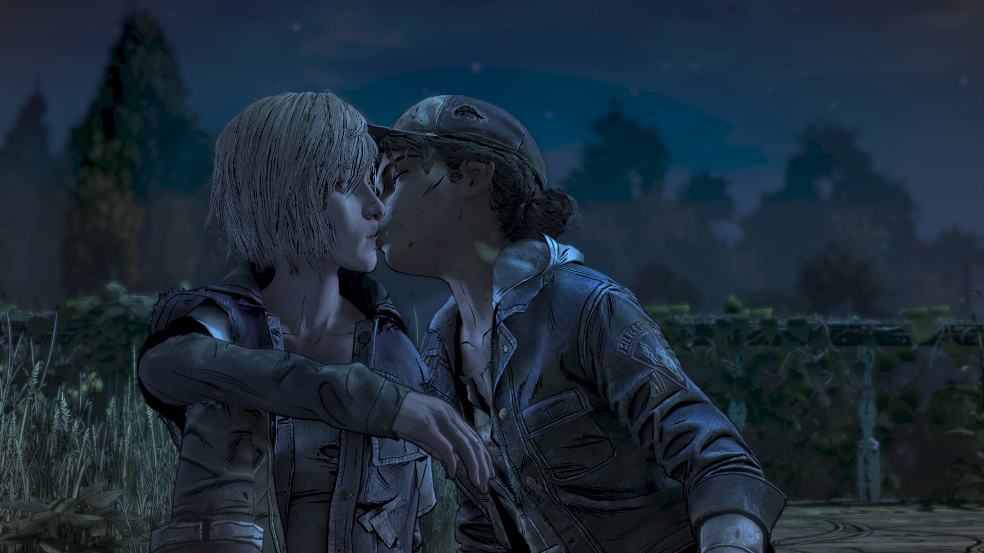 It's night-time and two young girls are outside. Clementine is on the right and she is leaning over and kissing the other girl with eyes closed. She has a tattered baseball cap and short black curly hair in a small bun. She has a cut on her left cheek and is wearing a jean jacket. Violet has blonde straight hair to her chin and looks surprised by the kiss, eyes still open. She's wearing a tattered hooded jacked and pants.